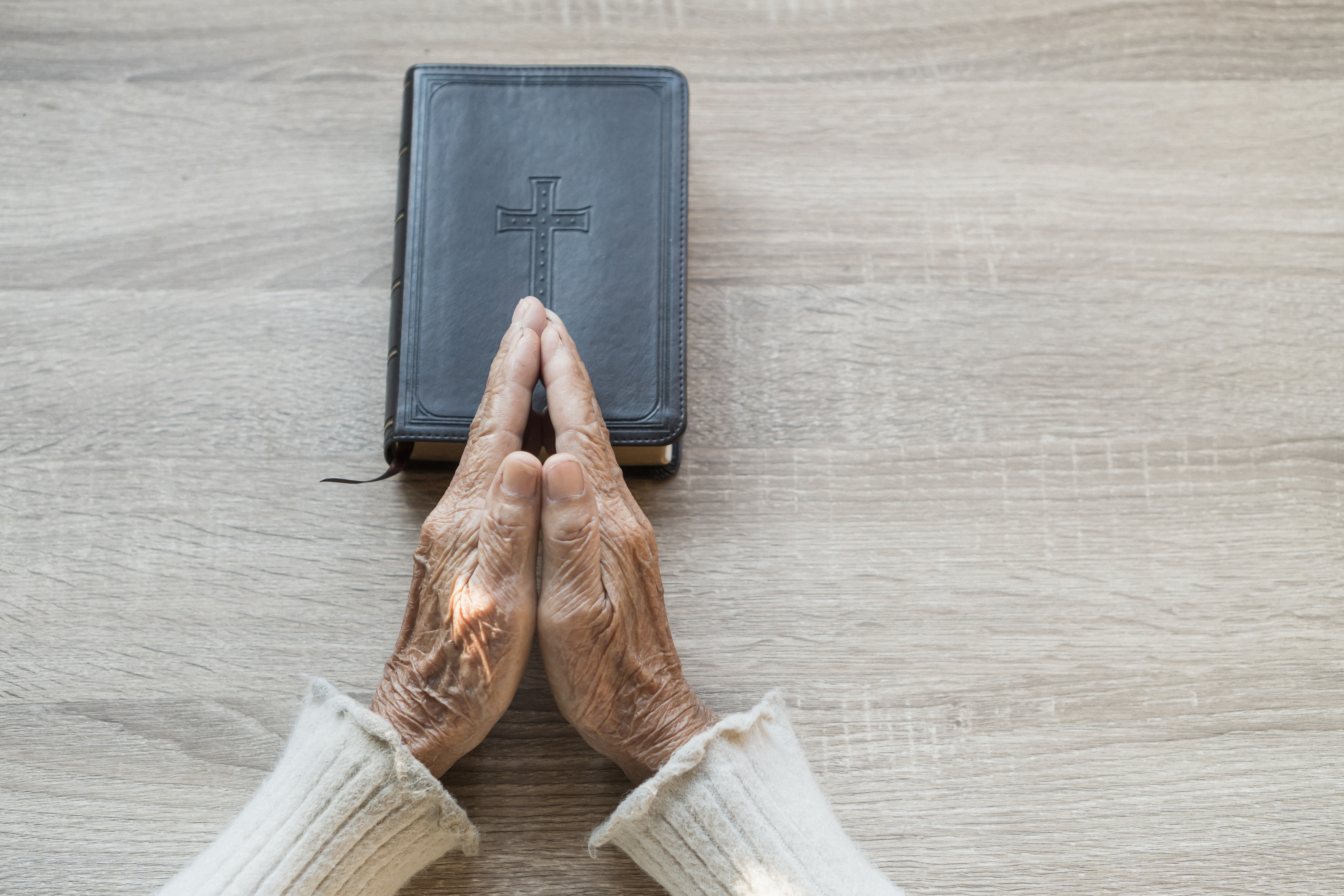 senior-hands-in-prayer-with-bible-on-table-2026-01-11-10-42-50-utc